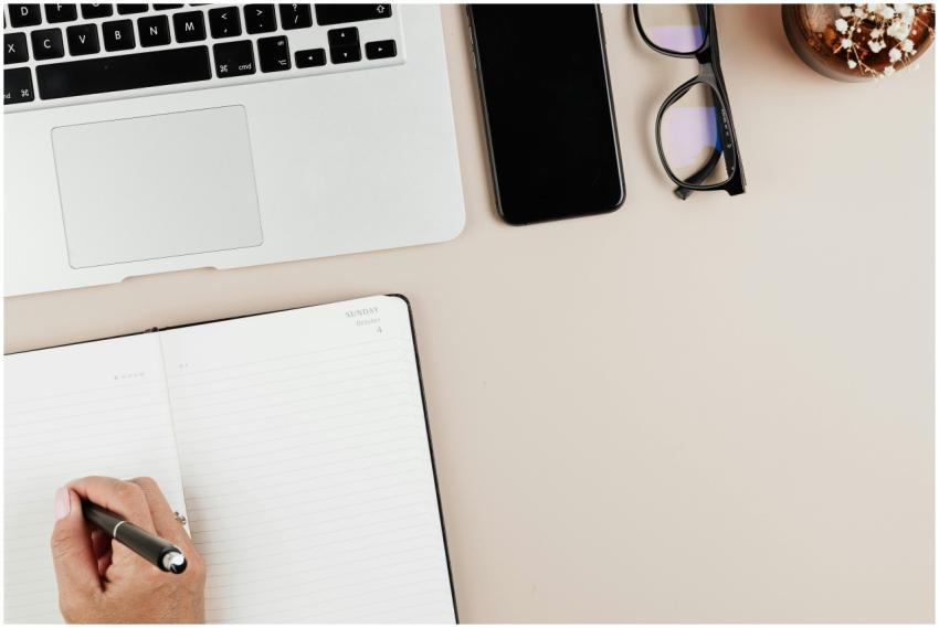 Top view of a modern workspace with a laptop, note