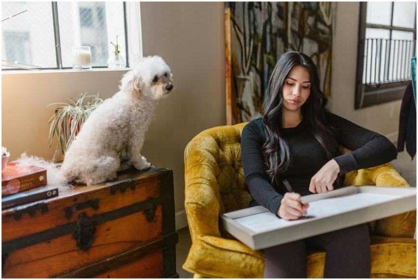 Woman drawing while sitting with her poodle. Cozy