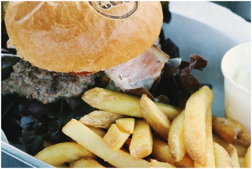 Close-up of a cheeseburger with lettuce and french