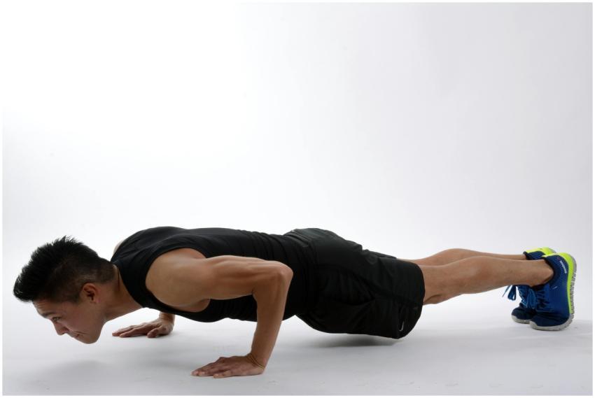 Young man in athletic wear doing push-ups, showcas