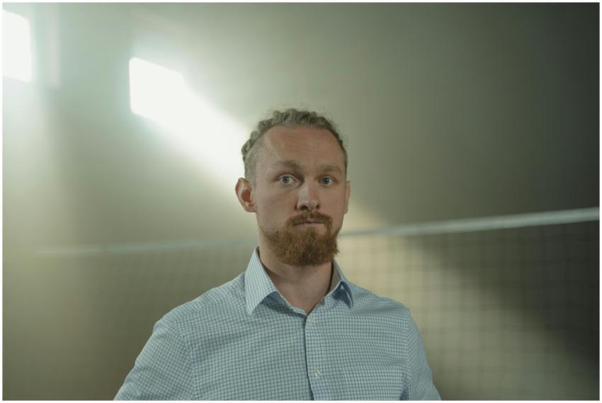 A thoughtful man standing in an illuminated indoor