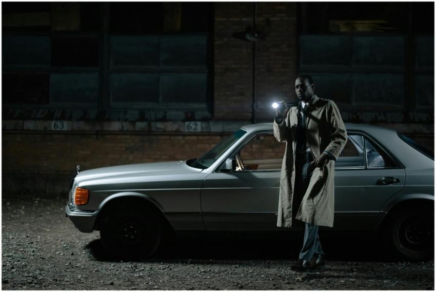 Detective conducting a night investigation by a ca