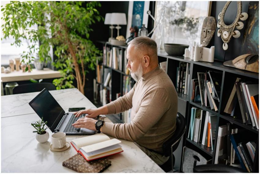 Senior man focused on laptop in a stylish home off