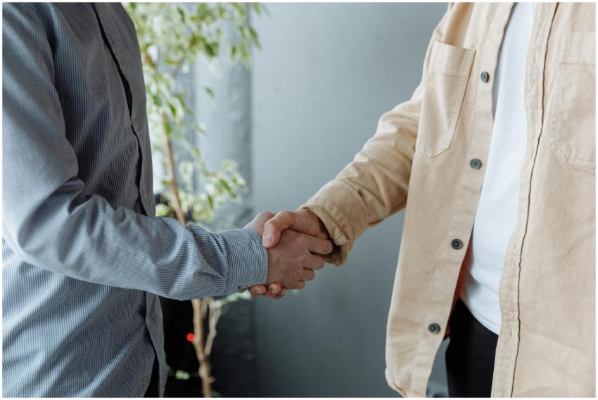 A close-up image of two businesspeople shaking han