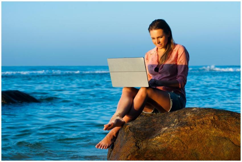 A woman relaxes on a rock by the sea in Sri Lanka,