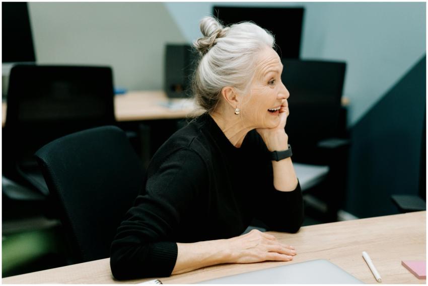 Senior businesswoman smiling at a desk in a modern