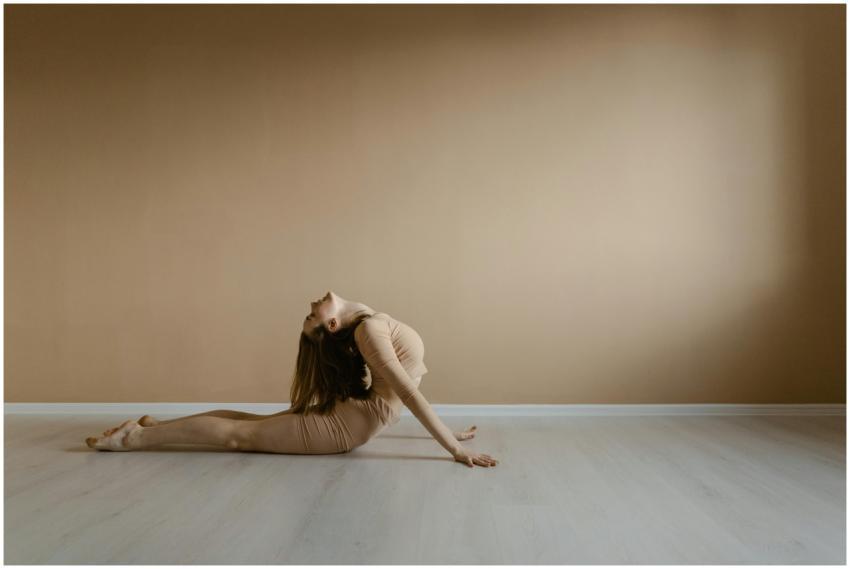 A woman demonstrates a flexible yoga pose in a min