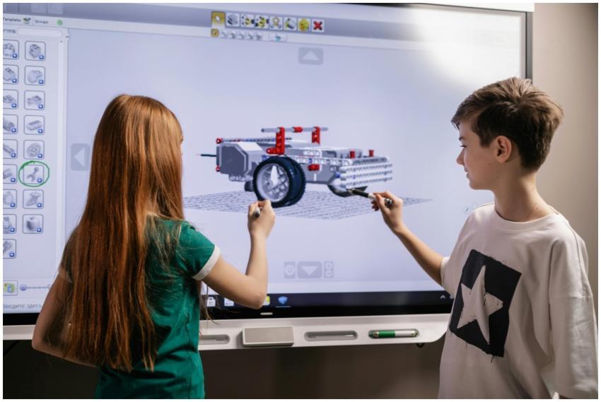 A boy and girl collaborate on a robotics project u