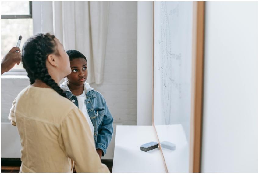 Two students attentively learning with a whiteboar