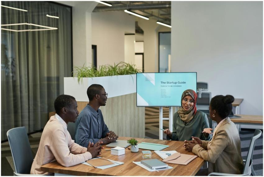 A diverse team discussing a startup guide in a mod