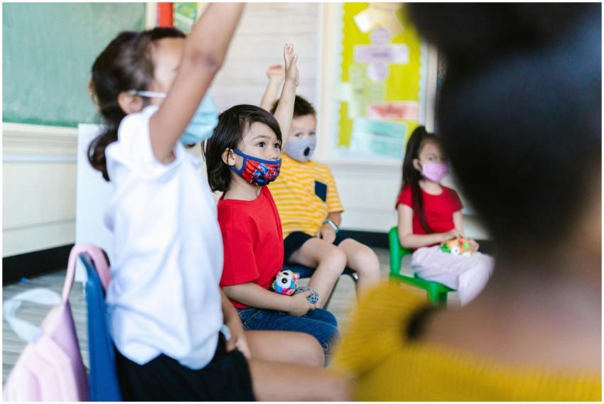 Diverse children in a classroom wearing masks and