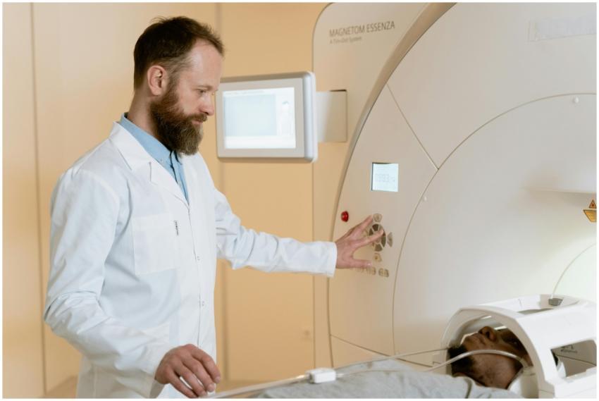 A doctor operates an MRI machine as a patient unde