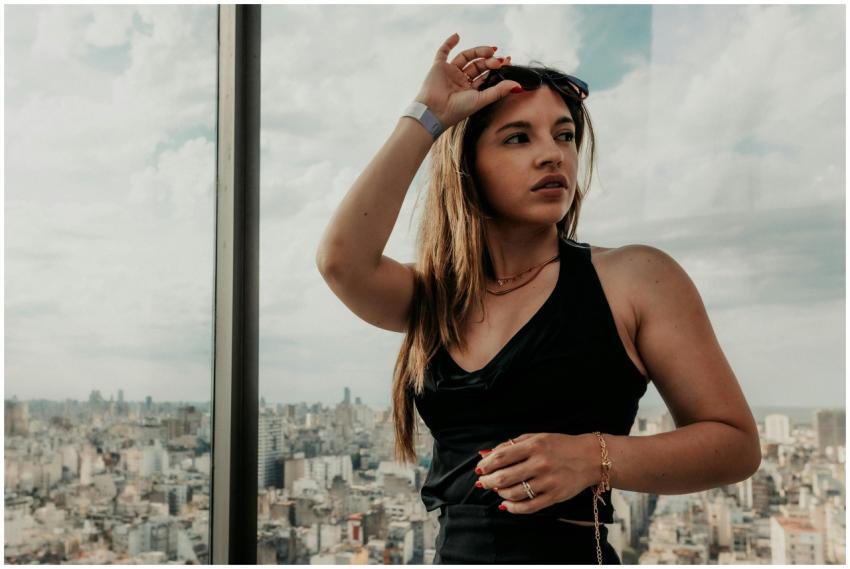 A stylish woman wearing sunglasses gazes over the