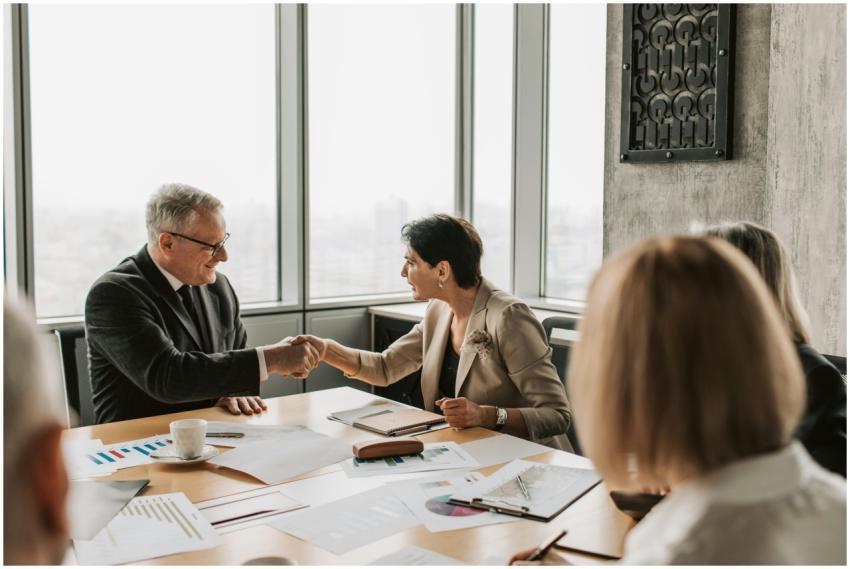 Colleagues in business attire shake hands during a