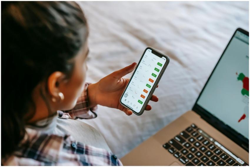 Female analyzing stock market data on her smartpho