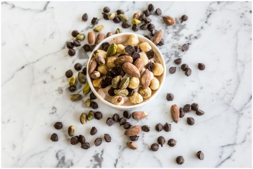 A bowl of mixed nuts and chocolate chips on a marb