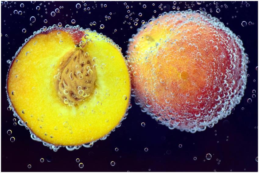 Close-up of ripe peaches submerged in water with a