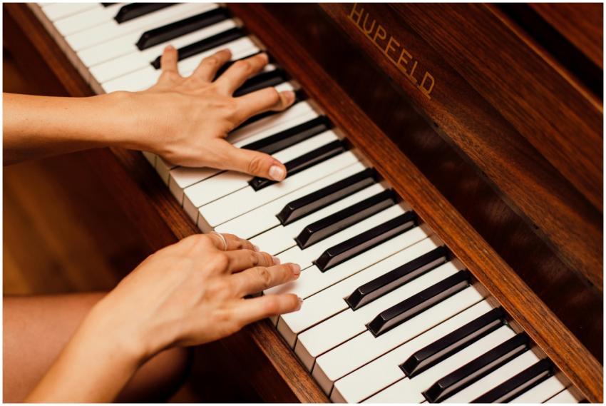 Musician's hands playing wooden piano keys in a hi