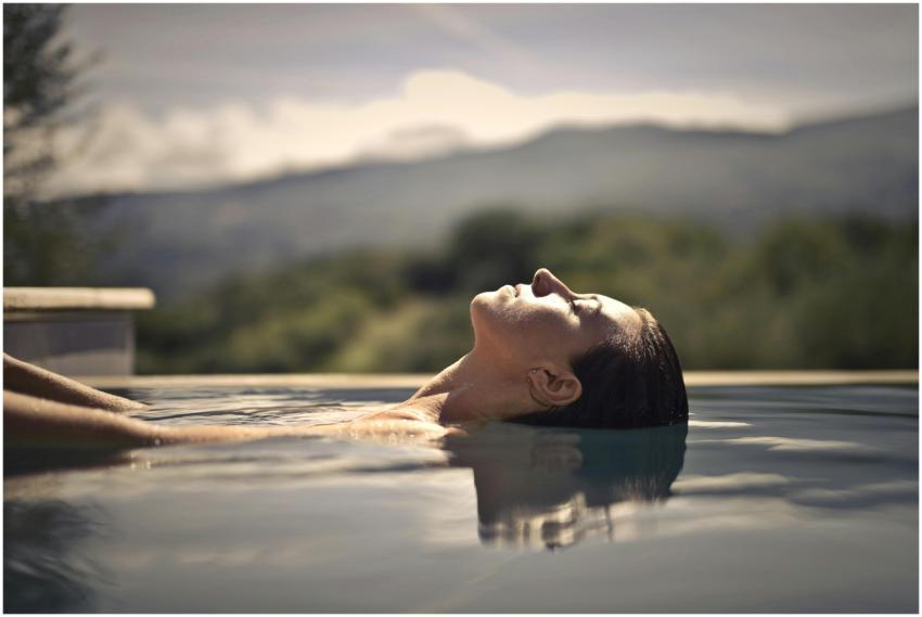 A woman enjoys a serene moment floating in a swimm