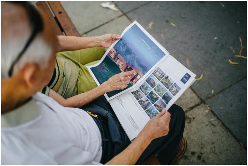 An elderly couple sitting outdoors on a bench read