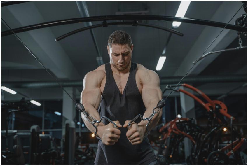 A strong man exercising on a cable crossover machi