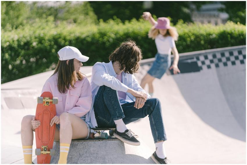 Three young skateboarders relaxing in a skatepark