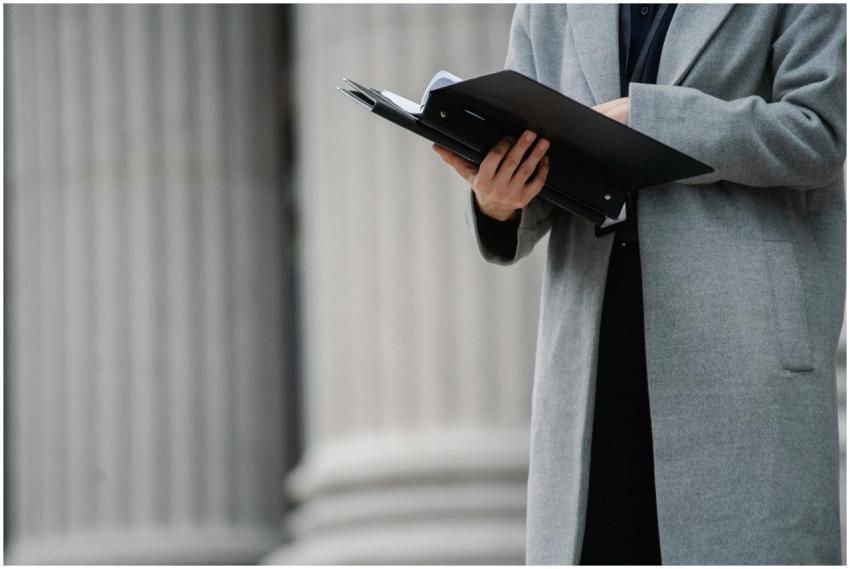 Professional woman in grey coat holding a folder o