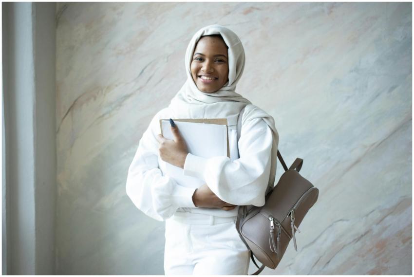 Young Muslim woman in hijab smiling with backpack