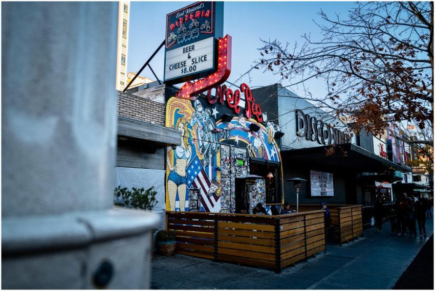 Street view of a vibrant pizza restaurant with neo