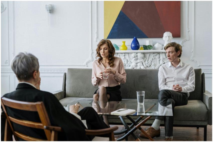 A couple conversing with a therapist in a chic, mo