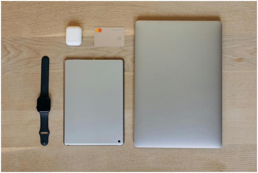 Top view of modern tech gadgets including a laptop