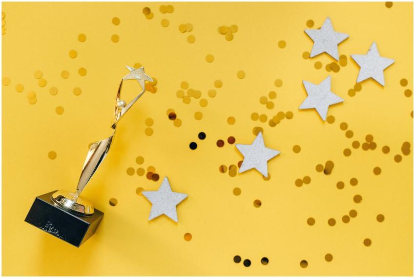 Shiny golden trophy and stars on a vibrant yellow