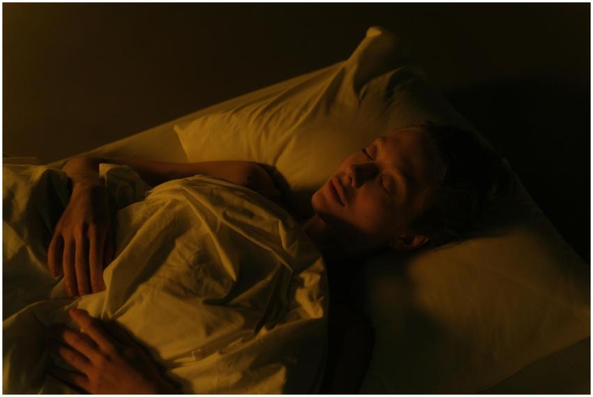 A woman peacefully sleeping in a dimly lit bedroom