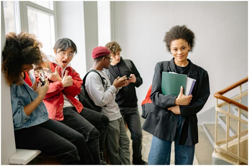 A group of diverse college students using smartpho