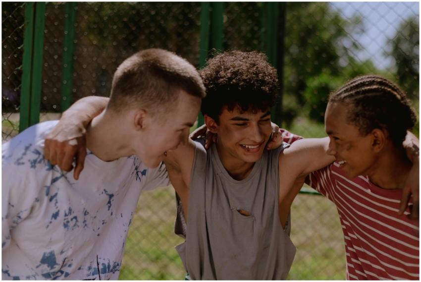Happy teenagers laughing and embracing outside, sh