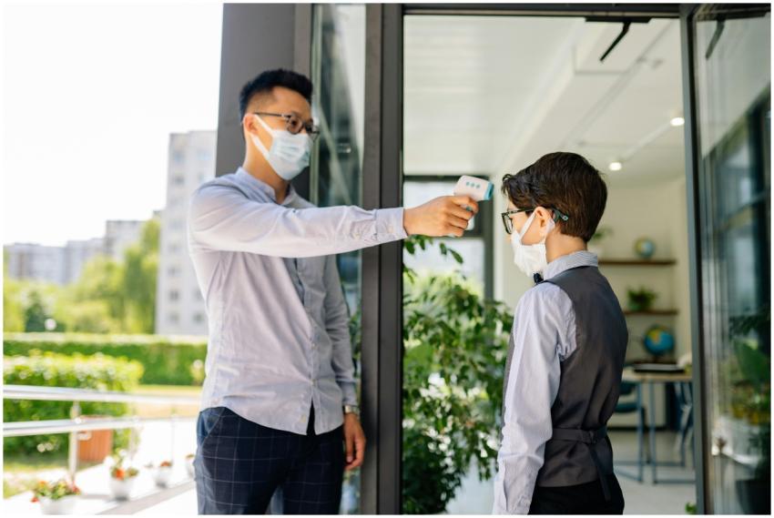 A man checks a child's temperature with a thermome