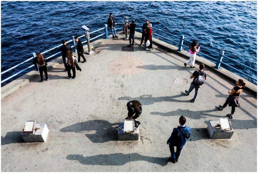 Individuals gather on a pier in Istanbul, offering