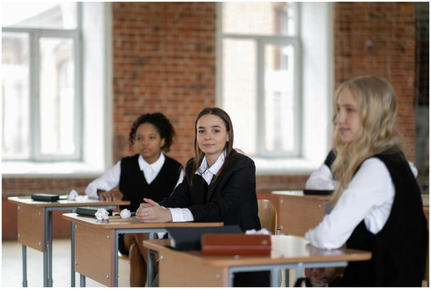 Students in uniform sitting at desks in a bright,