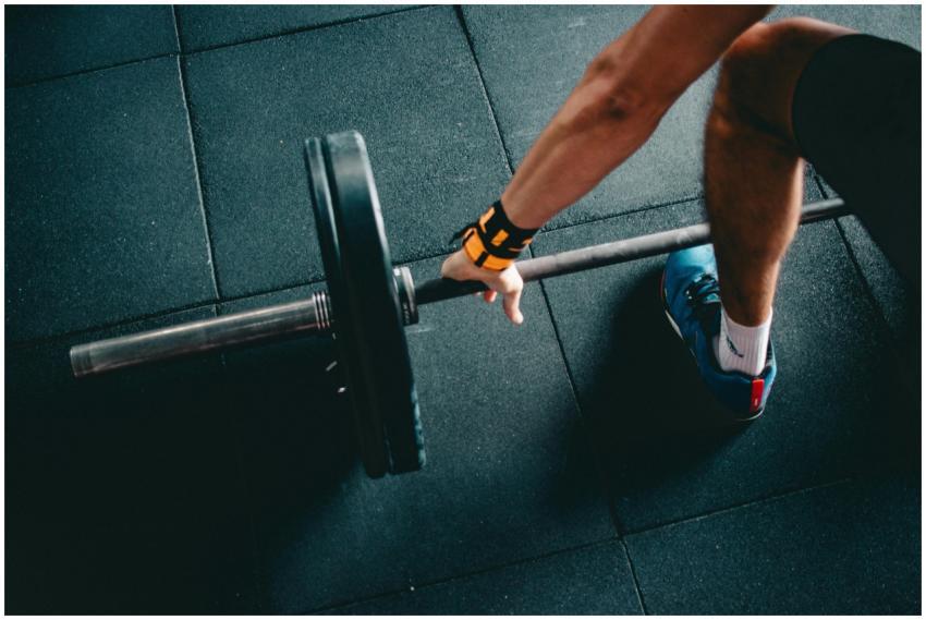 Close-up of a person lifting a barbell in an indoo