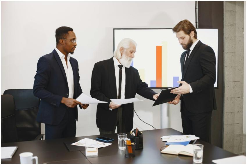 Three businessmen discussing documents in a confer
