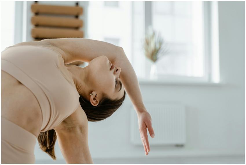Woman in sportswear practicing yoga indoors, empha