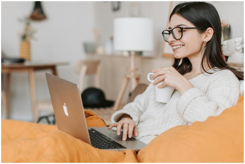 Woman enjoying a cozy moment with a laptop and cof