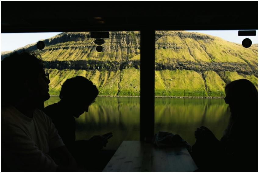Silhouettes of people in a cafe with stunning lake