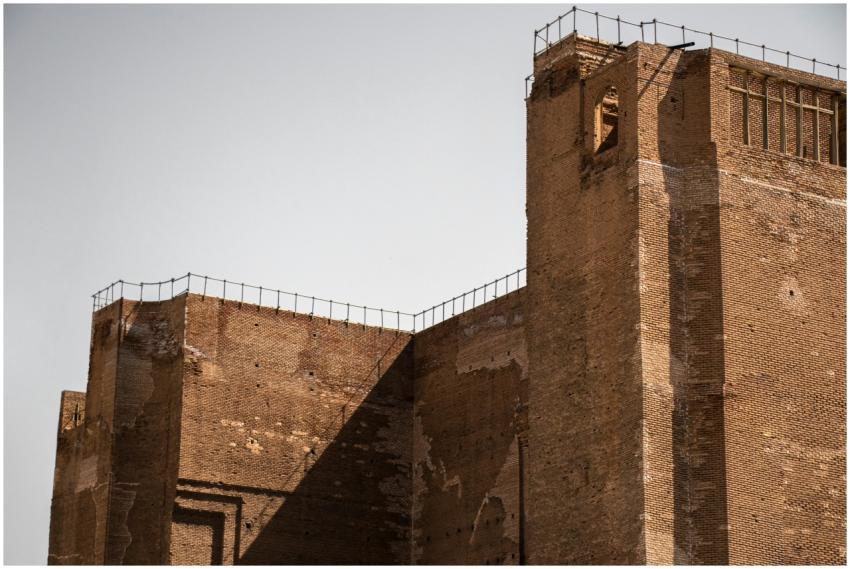 Brick walls of an ancient fortress tower under a c