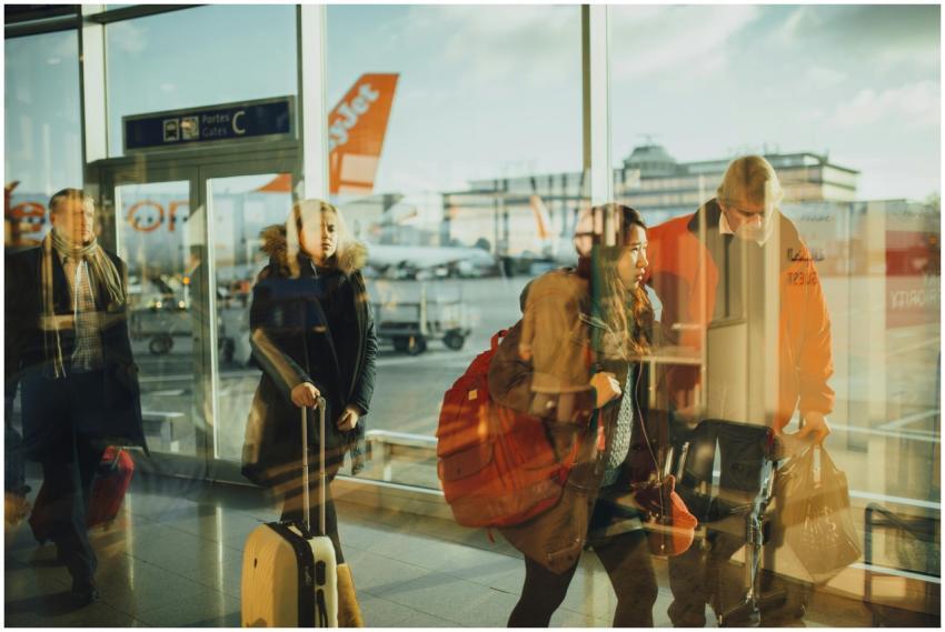 Passengers moving through an airport gate area wit