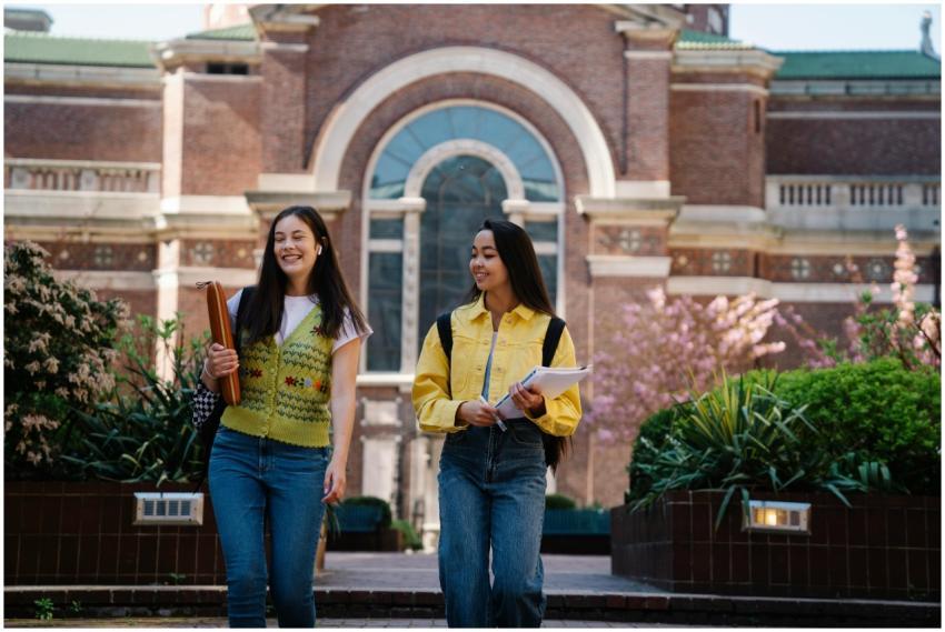 Two smiling young women walk together on a beautif