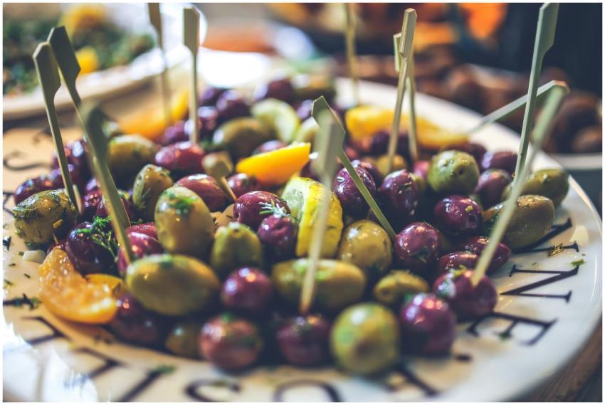 Close-up of assorted olives with skewers on a plat