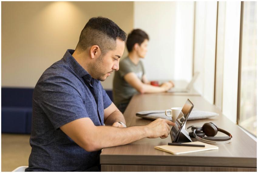 Two men working on devices in a modern office sett