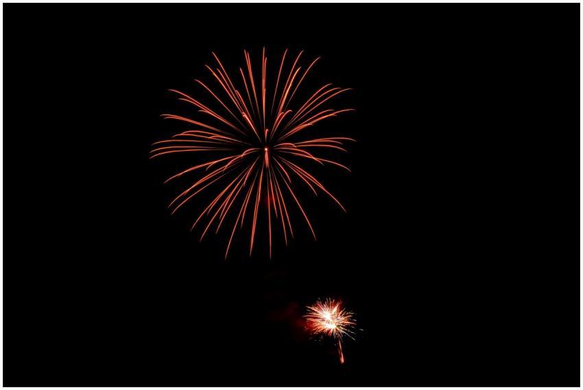 Bright fireworks light up the dark night sky in a