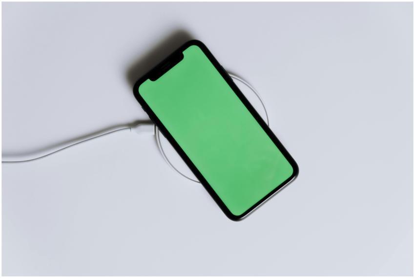 A minimalist smartphone with a green screen on a w